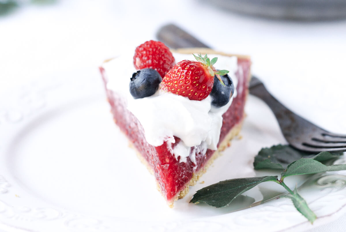Fun, pretty, and delicious! This gluten free and dairy free pie is made with a delicious graham cracker crust. Filled with fresh raspberry filling, and topped with whipped coconut cream and berries.