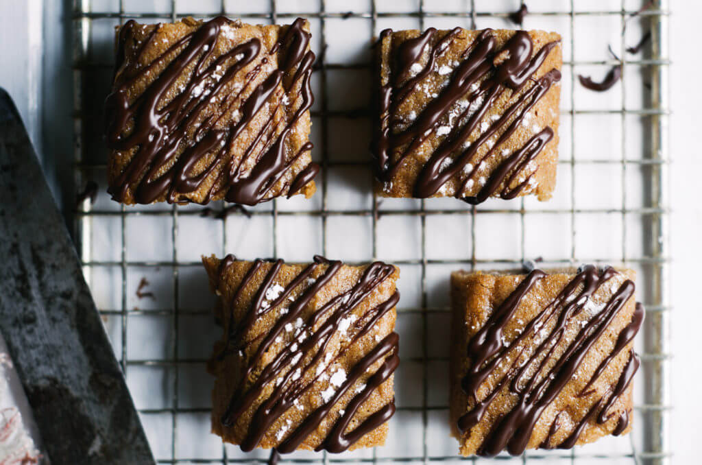 This Paleo snack cake is so incredibly moist and practically melts in your mouth. Tastefully drizzled with lushes chocolate sauce, this grain free dessert makes a perfect snack for those sweet tooth cravings.