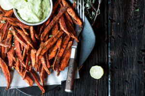 Cumin spiced sweet potato fries are paleo and gluten free. These tasty seasoned fries make the perfect healthy and delicious snack or side dish. This recipe is served with a creamy avocado garlic dipping sauce.