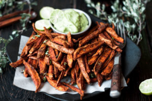 Cumin spiced sweet potato fries are paleo and gluten free. These tasty seasoned fries make the perfect healthy and delicious snack or side dish. This recipe is served with a creamy avocado garlic dipping sauce.