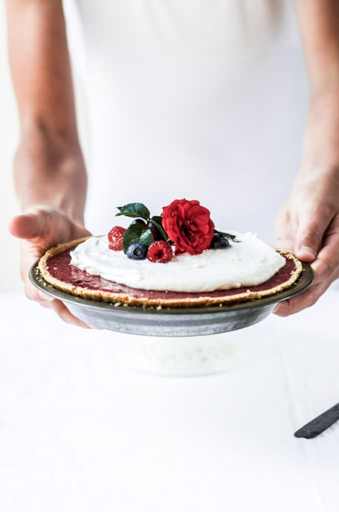 Fun, pretty, and delicious! This gluten free and dairy free pie is made with a delicious graham cracker crust. Filled with fresh raspberry filling, and topped with whipped coconut cream and berries.