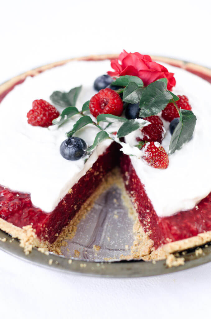 Fun, pretty, and delicious! This gluten free and dairy free pie is made with a delicious graham cracker crust. Filled with fresh raspberry filling, and topped with whipped coconut cream and berries.