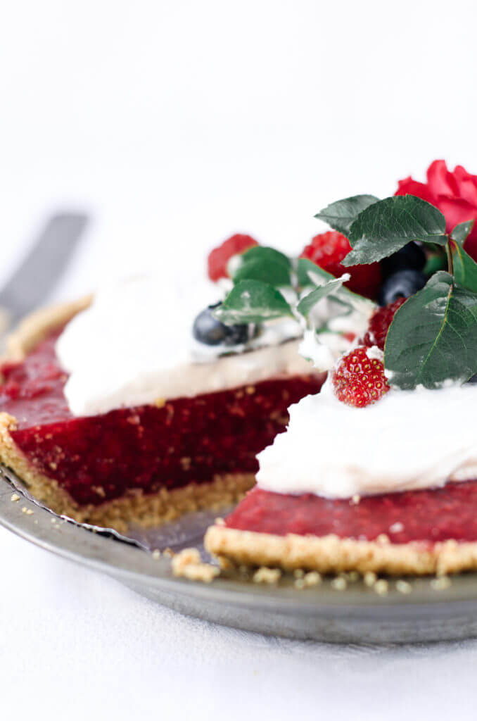 Fun, pretty, and delicious! This gluten free and dairy free pie is made with a delicious graham cracker crust. Filled with fresh raspberry filling, and topped with whipped coconut cream and berries.