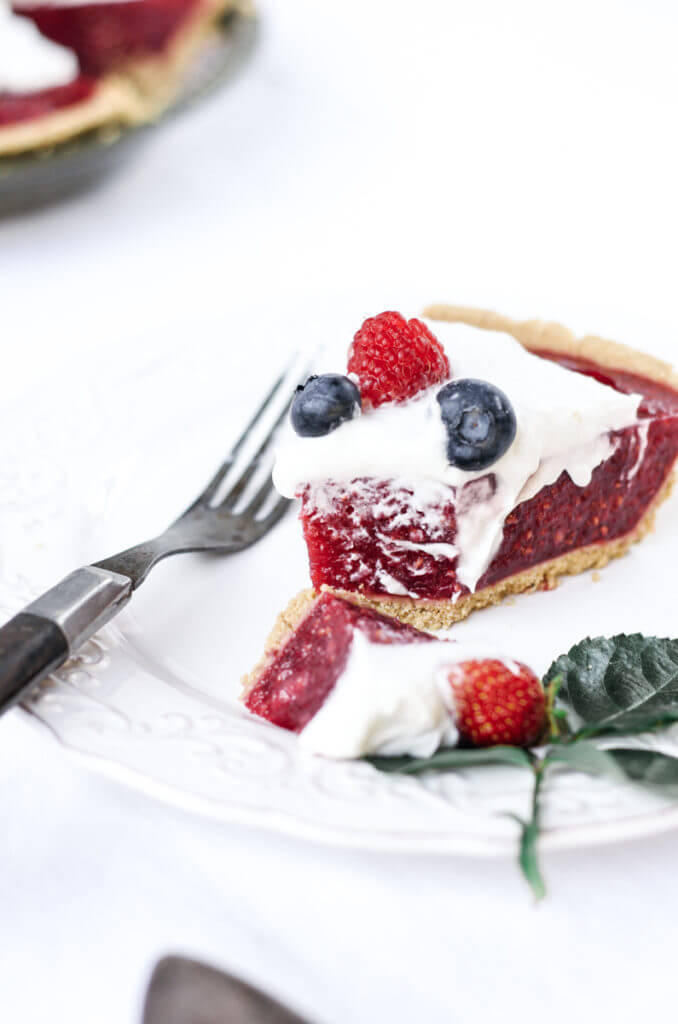 Fun, pretty, and delicious! This gluten free and dairy free pie is made with a delicious graham cracker crust. Filled with fresh raspberry filling, and topped with whipped coconut cream and berries.