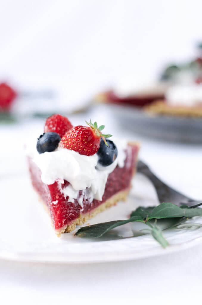 Fun, pretty, and delicious! This gluten free and dairy free pie is made with a delicious graham cracker crust. Filled with fresh raspberry filling, and topped with whipped coconut cream and berries.