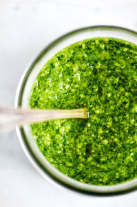 5 Minute Vegan Kale Pesto - made with pine nuts, olive oil, kale, parsley, garlic, salt, and lemon juice. So easy and extremely versatile for pizzas, salads, pasta, and breads! Less than 99 calories per serving. Easy whole30 pesto. paleo pesto recipe. Dairy free pesto. Best dairy free pesto recipe. Best whole30 pesto recipe.