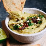 5 minute garlic lime cashew hummus is made without beans (gasp!). Made with soaked cashews, garlic, lime, parsley. Deliciously creamy, smooth, and full of flavor! Whole30 and paleo friendly. Served with paleo cassava flour pita chips! Whole30 hummus. Whole30 snacks. Paleo hummus. Paleo Snacks. easy cashew hummus dip. Hummus dip. best healthy hummus. Easy hummus recipe. Garlic lime hummus recipe.