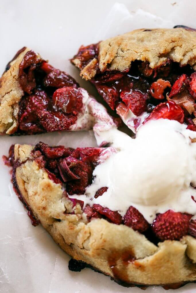 Incredibly easy grain free & paleo strawberry rhubarb galette. A healthy and simple summer treat made with whole food ingredients. Naturally gluten free and dairy free. Sweetened without refined sugar. That sugary gooey fruit filling is to die for! Especially paired with a light and “buttery” almond flour crust. Gluten free galette. Paleo fruit galette. best paleo strawberry galette. easy healthy galette recipe. paleo galette recipe. easy gluten free summer desserts. grain free pie crust. grain free strawberry rhubarb galette.