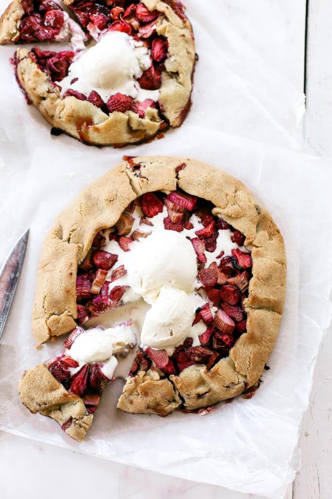 Incredibly easy grain free & paleo strawberry rhubarb galette. A healthy and simple summer treat made with whole food ingredients. Naturally gluten free and dairy free. Sweetened without refined sugar. That sugary gooey fruit filling is to die for! Especially paired with a light and “buttery” almond flour crust. Gluten free galette. Paleo fruit galette. best paleo strawberry galette. easy healthy galette recipe. paleo galette recipe. easy gluten free summer desserts. grain free pie crust. grain free strawberry rhubarb galette.