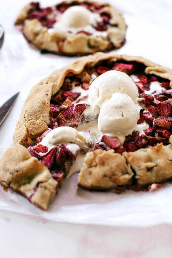 Incredibly easy grain free & paleo strawberry rhubarb galette. A healthy and simple summer treat made with whole food ingredients. Naturally gluten free and dairy free. Sweetened without refined sugar. That sugary gooey fruit filling is to die for! Especially paired with a light and “buttery” almond flour crust. Gluten free galette. Paleo fruit galette. best paleo strawberry galette. easy healthy galette recipe. paleo galette recipe. easy gluten free summer desserts. grain free pie crust. grain free strawberry rhubarb galette.