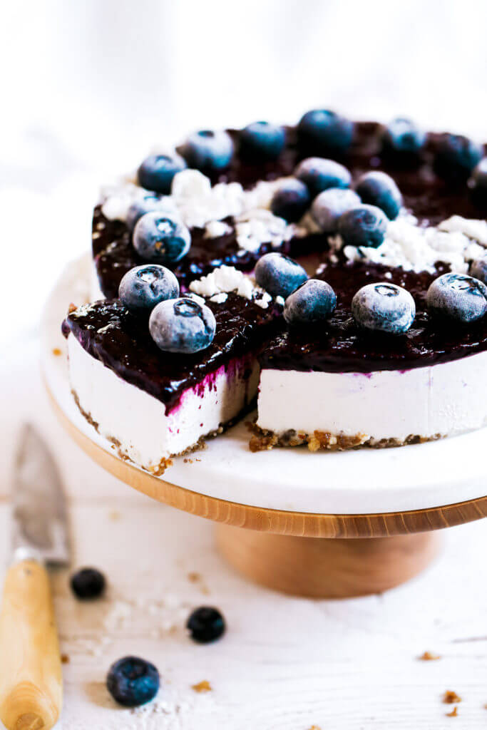 Can you believe it’s real!? Healthy paleo yogurt cheesecake recipe. Filled with a tangy and sweet creamy yogurt filling and topped off with fresh blueberry compote. Vegan, gluten free, and dairy free! Incredibly creamy and satisfying! Raw paleo cheesecake recipe. No bake cashew cheesecake. Best gluten free vegan cheesecake. Raw paleo cheesecake recipe. No bake cheesecake recipe. Paleo cream cheese. Best paleo dessert recipes. easy cashew cheesecake. Blueberry cake recipes. best paleo blueberry cake. cherry photography. cake photography.