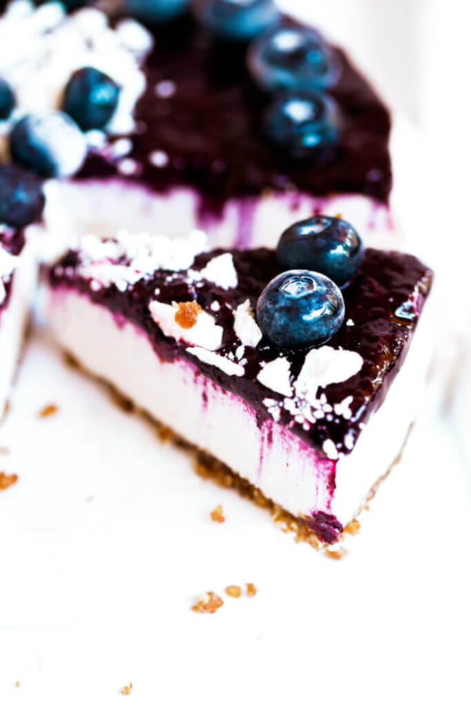 Can you believe it’s real!? Healthy paleo yogurt cheesecake recipe. Filled with a tangy and sweet creamy yogurt filling and topped off with fresh blueberry compote. Vegan, gluten free, and dairy free! Incredibly creamy and satisfying! Raw paleo cheesecake recipe. No bake cashew cheesecake. Best gluten free vegan cheesecake. Raw paleo cheesecake recipe. No bake cheesecake recipe. Paleo cream cheese. Best paleo dessert recipes. easy cashew cheesecake. Blueberry cake recipes. best paleo blueberry cake. cherry photography. cake photography.