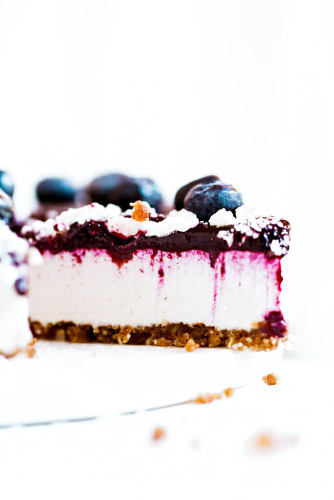 Can you believe it’s real!? Healthy paleo yogurt cheesecake recipe. Filled with a tangy and sweet creamy yogurt filling and topped off with fresh blueberry compote. Vegan, gluten free, and dairy free! Incredibly creamy and satisfying! Raw paleo cheesecake recipe. No bake cashew cheesecake. Best gluten free vegan cheesecake. Raw paleo cheesecake recipe. No bake cheesecake recipe. Paleo cream cheese. Best paleo dessert recipes. easy cashew cheesecake. Blueberry cake recipes. best paleo blueberry cake. cherry photography. cake photography.