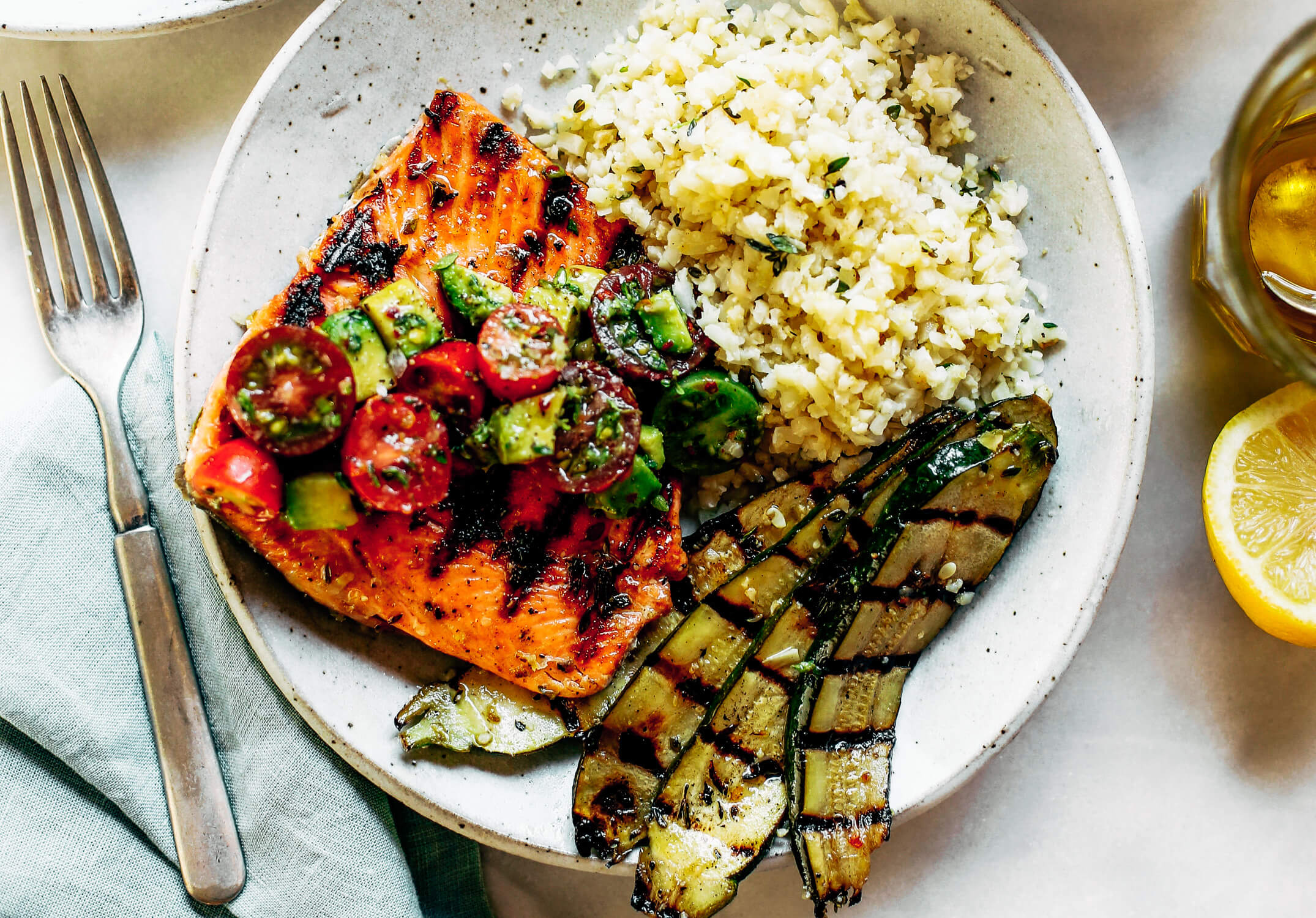 Lemony thyme grilled salmon with cauliflower rice and grilled zucchini. A healthy, light, and fresh whole30 dinner idea! An easy paleo meal for the whole family. Paleo dinner and lunch recipes. Easy paleo diet recipes. Whole30 lunch salad. Whole30 dinner recipes. Whole30 meal prep and sides. Best healthy summer dinner recipes. Grilled salmon recipes.