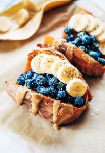 Baked sweet potatoes stuffed with blueberries, bananas, and cashew butter make a tasty whole30 vegan breakfast! You can make them ahead of time for whole30 meal prep. This easy paleo breakfast makes a great snack anytime of day! #paleo #mealprep #whole30 #vegan