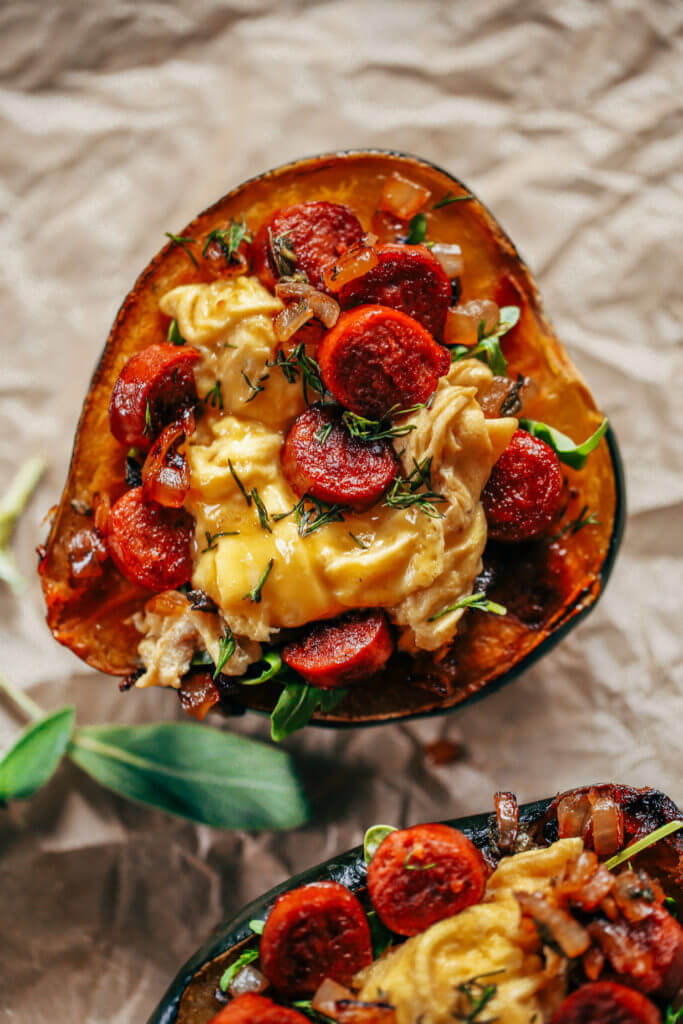Whole30 breakfast stuffed acorn squash makes a great breakfast, lunch or dinner! Soft scrambled eggs, crispy sausage, sage, and onions all stuffed in a roasted acorn squash makes for easy paleo breakfast meal prep. Best whole30 breakfast recipe for beginners. #whole30 #mealprep #paleo #breakfast #fall