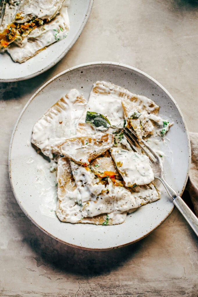 2 Ingredient ravioli made with sweet potato! Filled with butternut kale sage filling and served with cream sauce. A delicious paleo family dinner the whole family will love! Paleo pasta recipe made with white sweet potato. #pasta #paleodiet #healthydinners #mealprep #kale