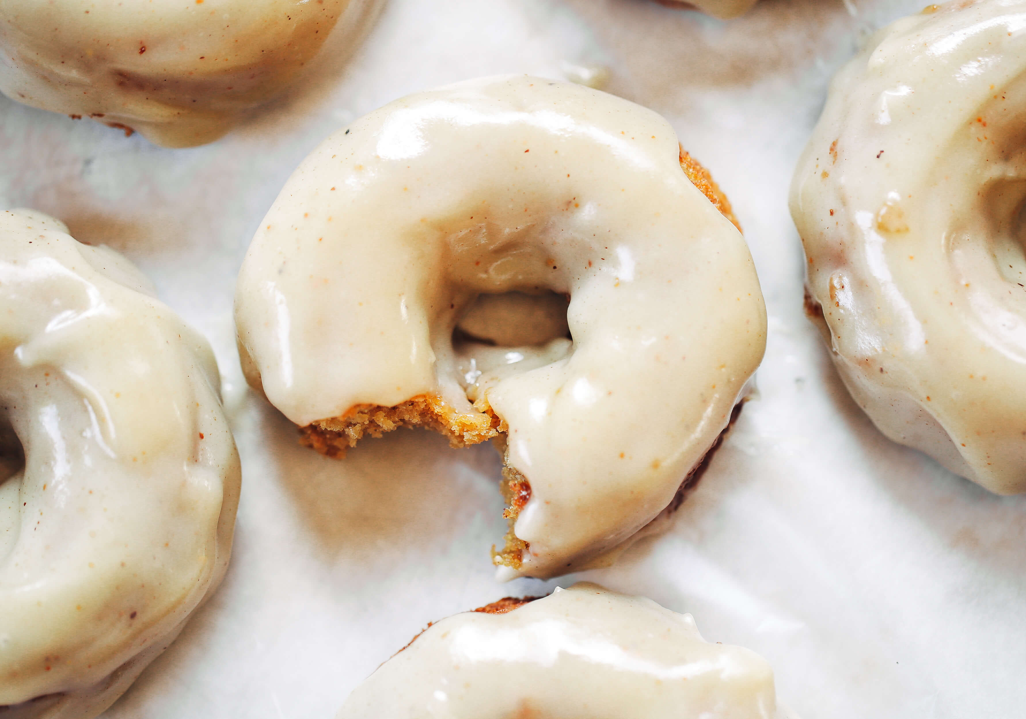 Ready for this fall favorite? Paleo pumpkin pie glazed donuts- made with white sweet potato instead of flour... It truly doesn't get any better! The texture is soft and fluffy, the flavor is pumpkin pie in real life, and the glaze is EVERYTHING. Easy gluten free donut recipe. Best paleo baked donuts! #paleo #donuts #pumpkinspice #baking