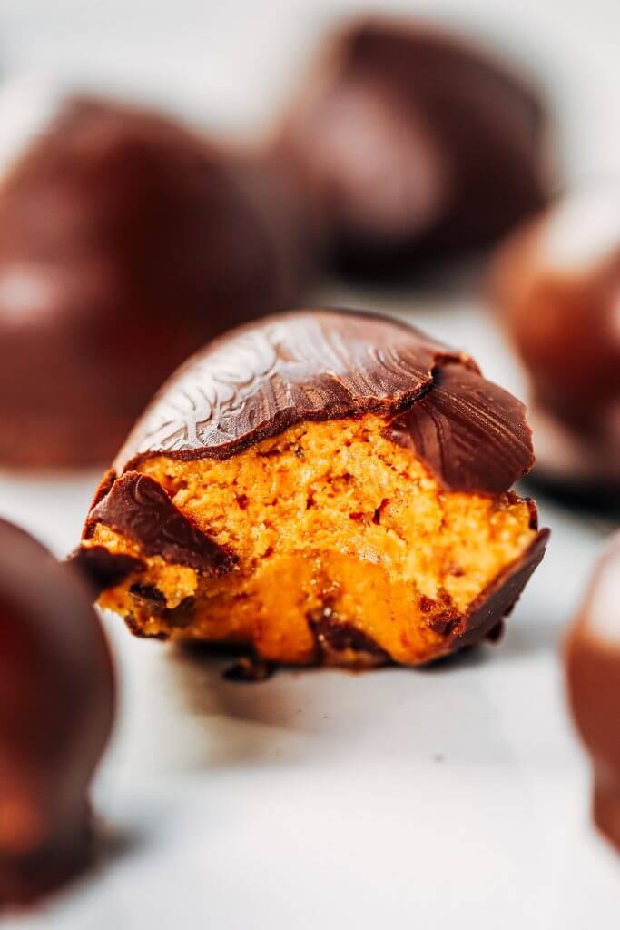 Low calorie snack balls made with nut butter and coated in a chocolate shell. An easy paleo snack for on the go! Perfect healthy snack or breakfast for kids and busy families. #healthysnacks #paleo #chocolate #vegan