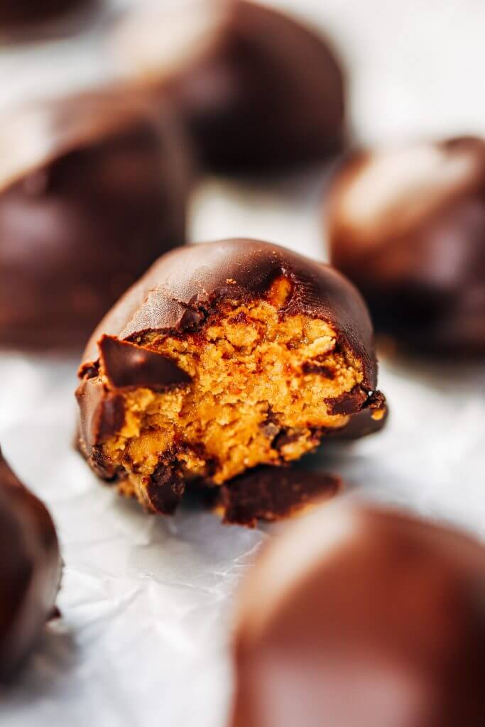 Low calorie snack balls made with nut butter and coated in a chocolate shell. An easy paleo snack for on the go! Perfect healthy snack or breakfast for kids and busy families. #healthysnacks #paleo #chocolate #vegan