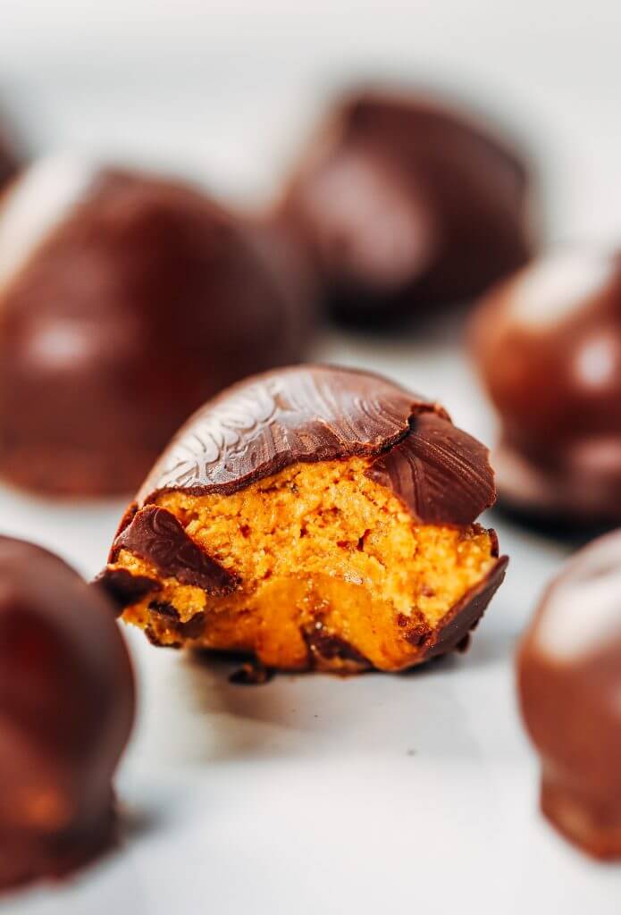 Low calorie snack balls made with nut butter and coated in a chocolate shell. An easy paleo snack for on the go! Perfect healthy snack or breakfast for kids and busy families. #healthysnacks #paleo #chocolate #vegan