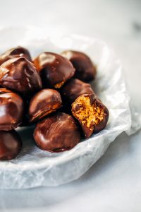 Low calorie snack balls made with nut butter and coated in a chocolate shell. An easy paleo snack for on the go! Perfect healthy snack or breakfast for kids and busy families. #healthysnacks #paleo #chocolate #vegan