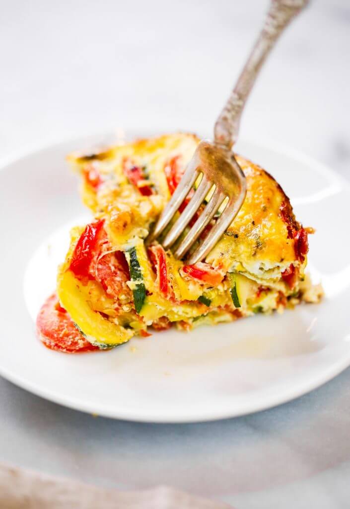 Easy whole30 egg and zucchini breakfast bake with tomatoes, yellow squash, herbs, and zucchini. This paleo breakfast is perfect for meal prep at the beginning of the week and paired with one of my homemade sweet potato tortillas! #paleo #whole30 #bacon