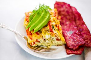 Easy whole30 egg and zucchini breakfast bake with tomatoes, yellow squash, herbs, and zucchini. This paleo breakfast is perfect for meal prep at the beginning of the week and paired with one of my homemade sweet potato tortillas! #paleo #whole30 #bacon