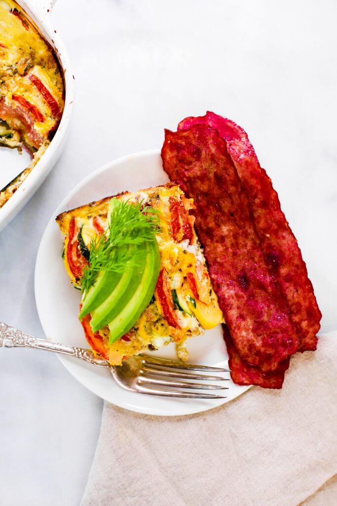 Easy whole30 egg and zucchini breakfast bake with tomatoes, yellow squash, herbs, and zucchini. This paleo breakfast is perfect for meal prep at the beginning of the week and paired with one of my homemade sweet potato tortillas! #paleo #whole30 #bacon