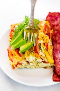 Easy whole30 egg and zucchini breakfast bake with tomatoes, yellow squash, herbs, and zucchini. This paleo breakfast is perfect for meal prep at the beginning of the week and paired with one of my homemade sweet potato tortillas! #paleo #whole30 #bacon