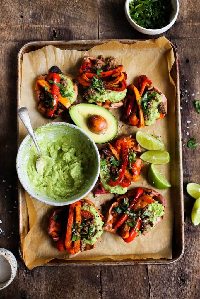 Easy vegan fajita smashed potatoes. This easy whole30 and paleo sheet pan dinner is delicious served with creamy avocado lime dip. Smashed baked sweet potatoes with fajita seasoned bell peppers.