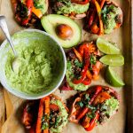 Easy vegan fajita smashed potatoes. This easy whole30 and paleo sheet pan dinner is delicious served with creamy avocado lime dip. Smashed baked sweet potatoes with fajita seasoned bell peppers.