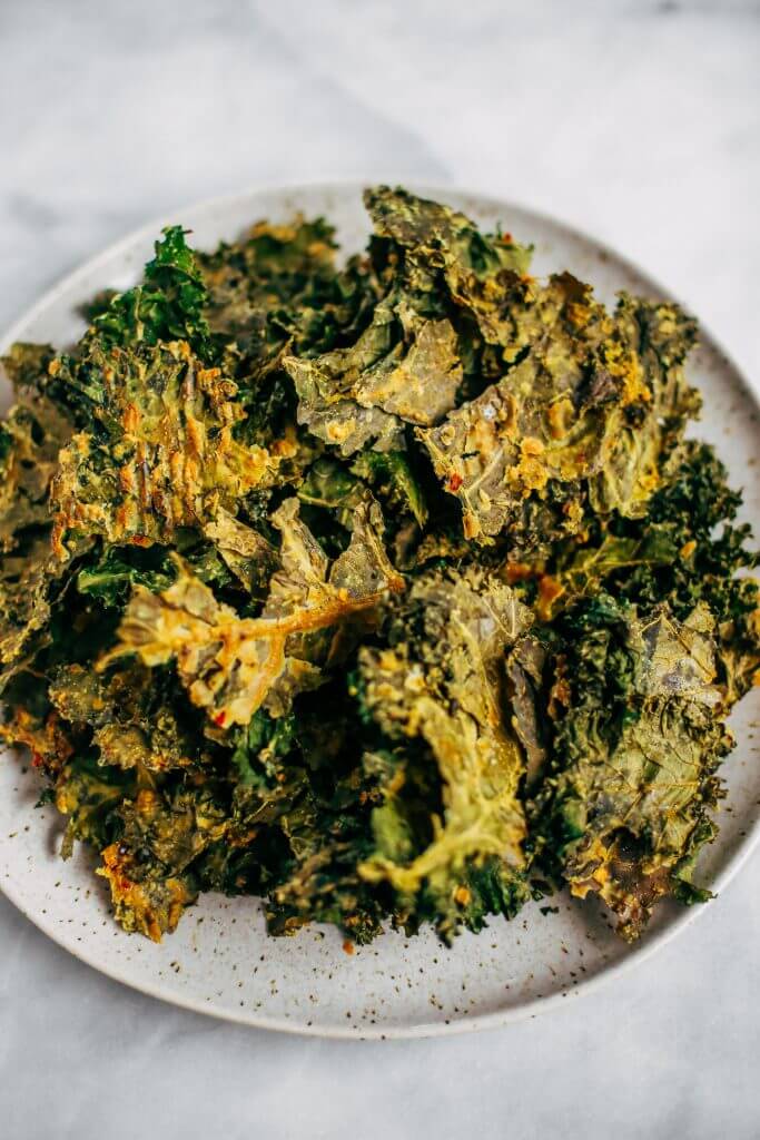 Zesty lemon garlic kale chips. Homemade kale chip recipe. Easy whole30 snack for on the go. These healthy paleo kale chips are made with just a few ingredients and are SO easy to make! #whole30 #paleo #vegan #recipe #cooking